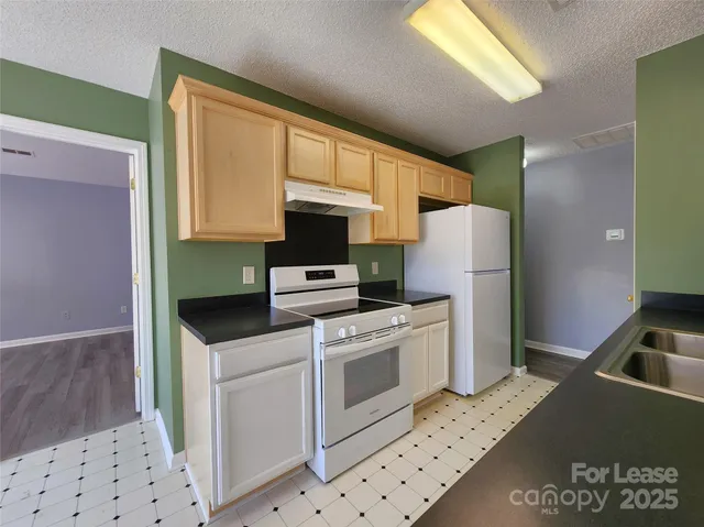 a kitchen with a refrigerator sink and stove top oven