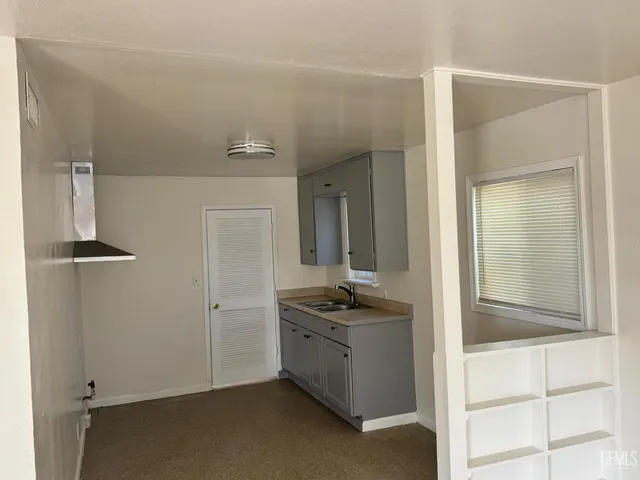 a view of kitchen with sink refrigerator and window