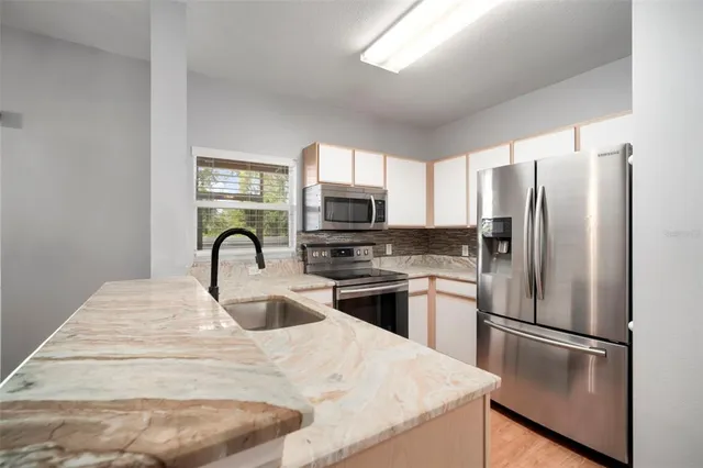a kitchen with stainless steel appliances a refrigerator stove and microwave