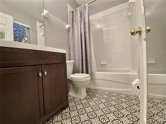 a bathroom with a sink a toilet a mirror and shower