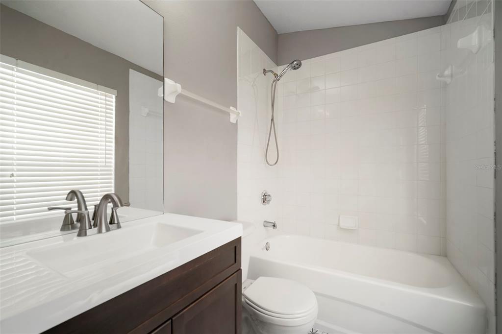 1231 Charlesworth Drive Wesley Chapel, FL 33543 - Photo 33 of 41 a bathroom with a granite countertop sink a toilet and shower
