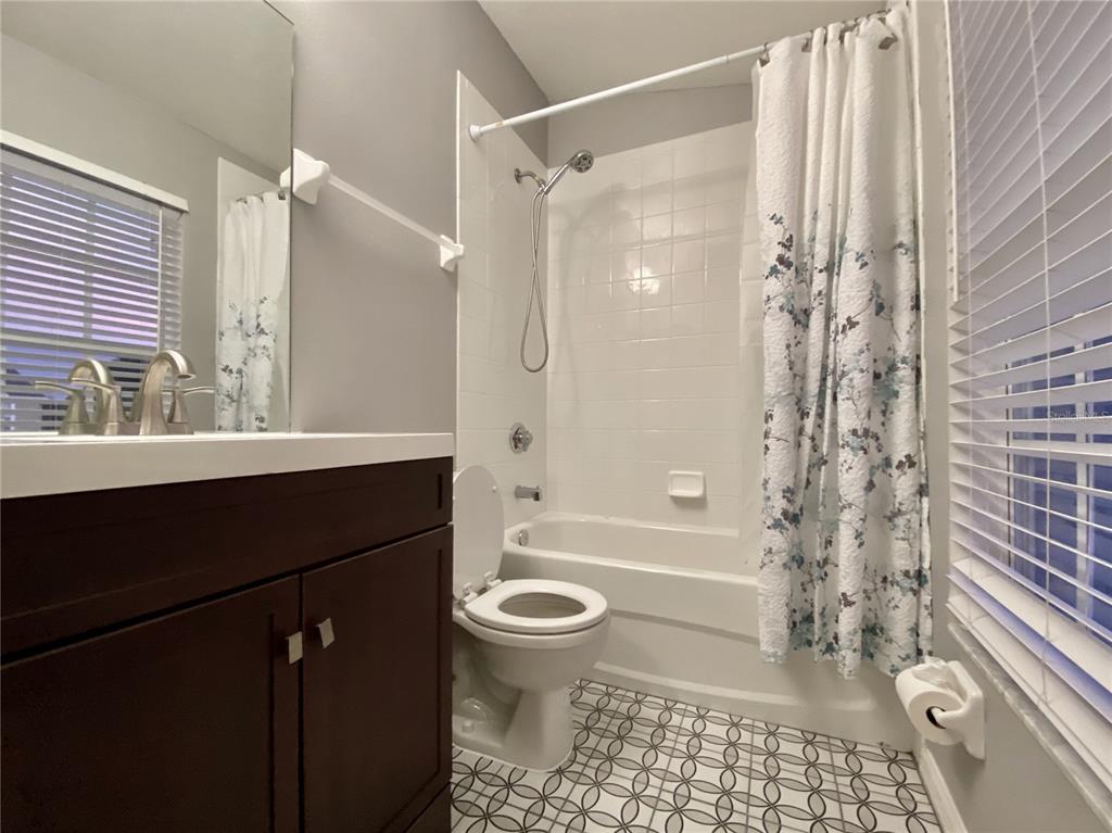 1231 Charlesworth Drive Wesley Chapel, FL 33543 - Photo 34 of 41 a bathroom with a sink a toilet a mirror and shower
