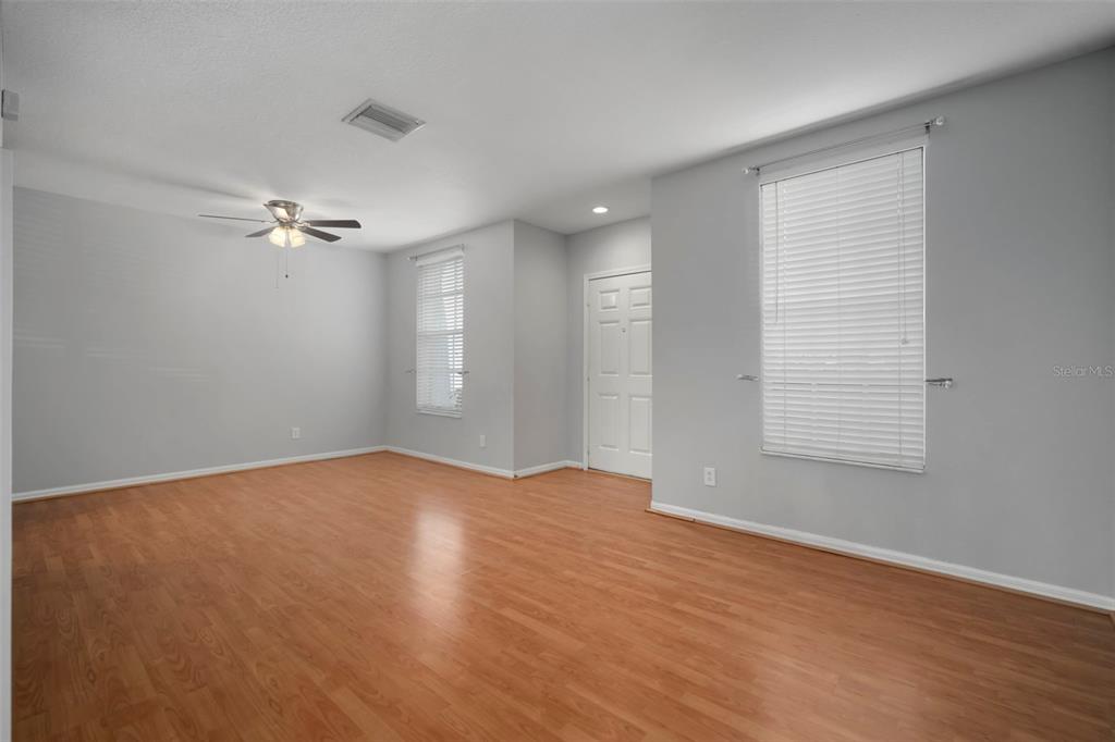 1231 Charlesworth Drive Wesley Chapel, FL 33543 - Photo 9 of 41 a view of a room with wooden floor and a ceiling fan