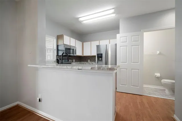 a kitchen with stainless steel appliances kitchen island granite countertop a refrigerator a stove a sink a microwave and island