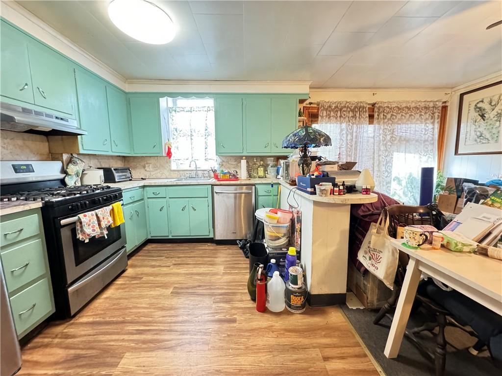 451 73rd Street Brooklyn, NY 11209 - Photo 11 of 16 a kitchen with stainless steel appliances a stove a sink cabinets and a dining table