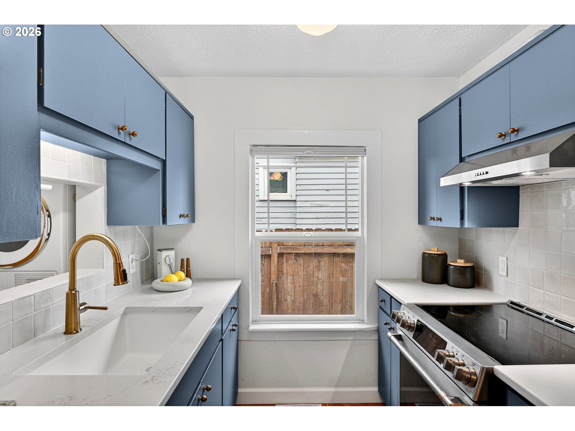 6128 Southeast Reedway Street Portland, OR 97206 - Photo 13 of 40 a kitchen with a sink a stove and cabinets