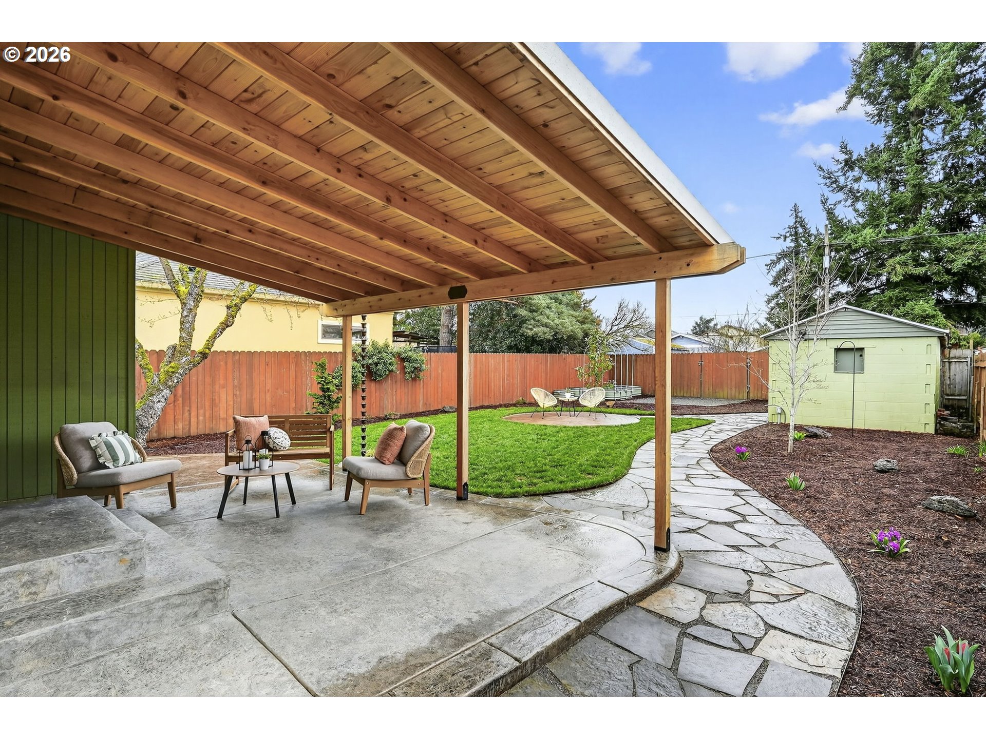 6128 Southeast Reedway Street Portland, OR 97206 - Photo 28 of 40 a view of a backyard with table and chairs under an umbrella with a barbeque grill and plants