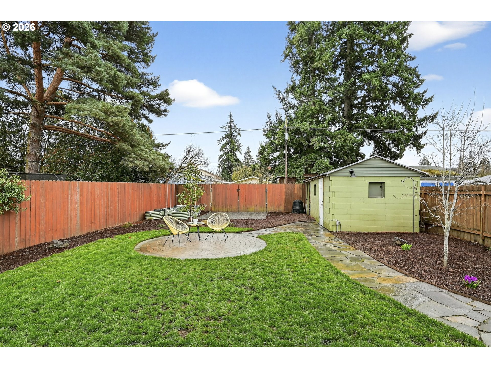 6128 Southeast Reedway Street Portland, OR 97206 - Photo 32 of 40 a backyard of a house with table and chairs