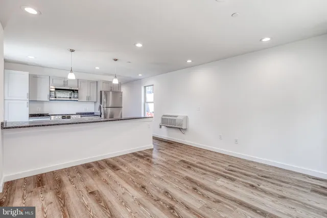a large kitchen with a lot of counter space and stainless steel appliances