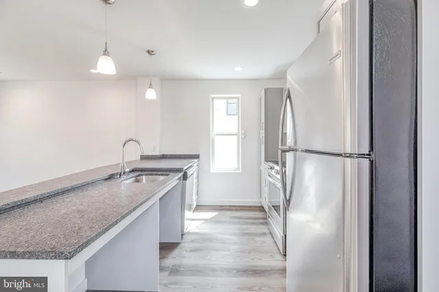 a kitchen with a refrigerator and a sink