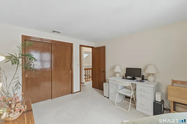 a bathroom with a toilet a sink a mirror and a window