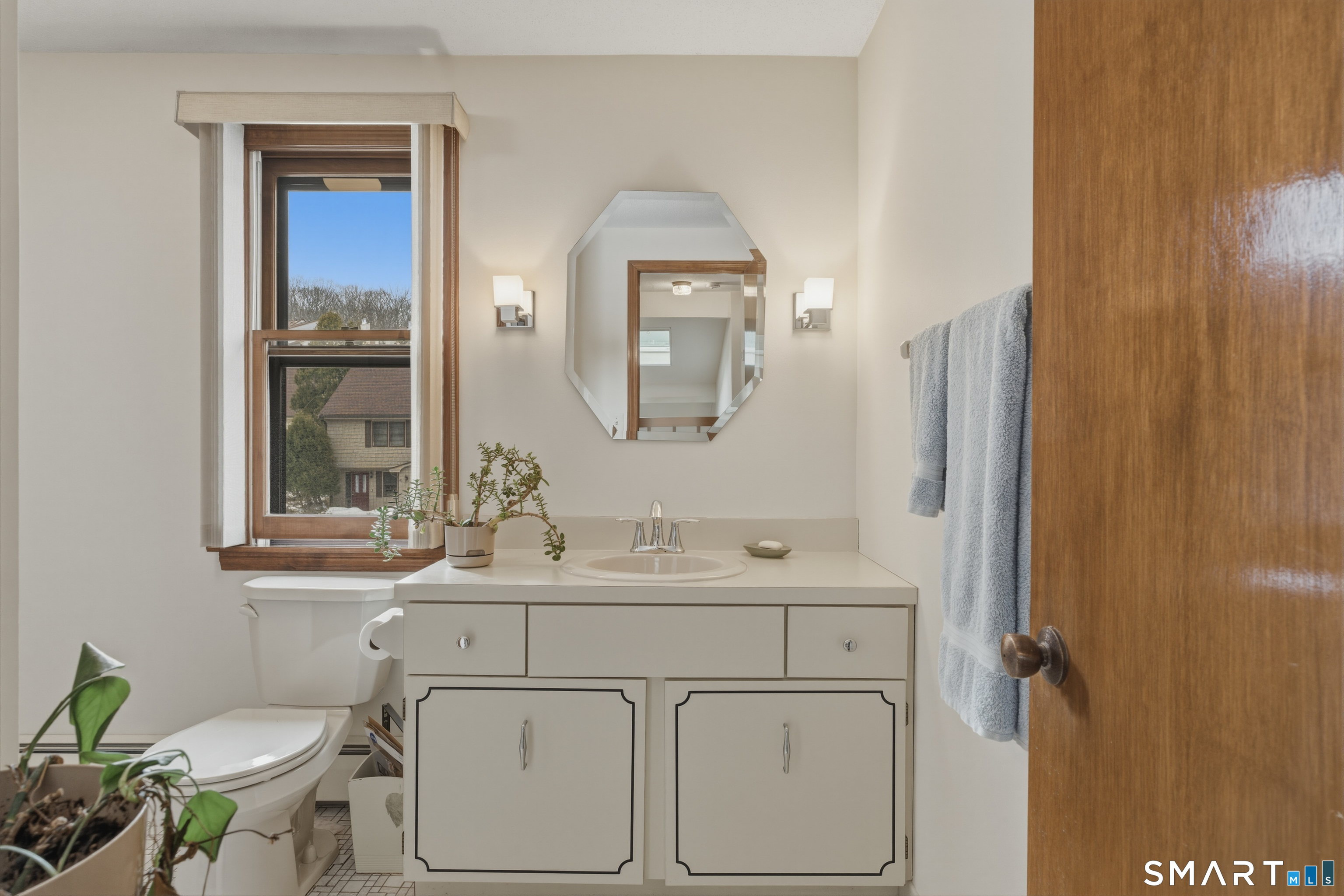 15 Potter Crossing, Unit 15 Wethersfield, CT 06109 - Photo 17 of 21 a bathroom with a toilet a sink a mirror and a window