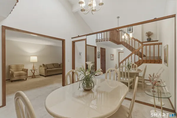 a view of a dining room with furniture and a chandelier