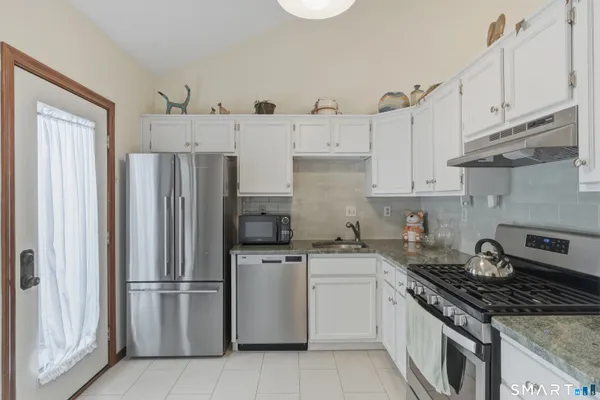 a kitchen with cabinets stainless steel appliances and a counter space