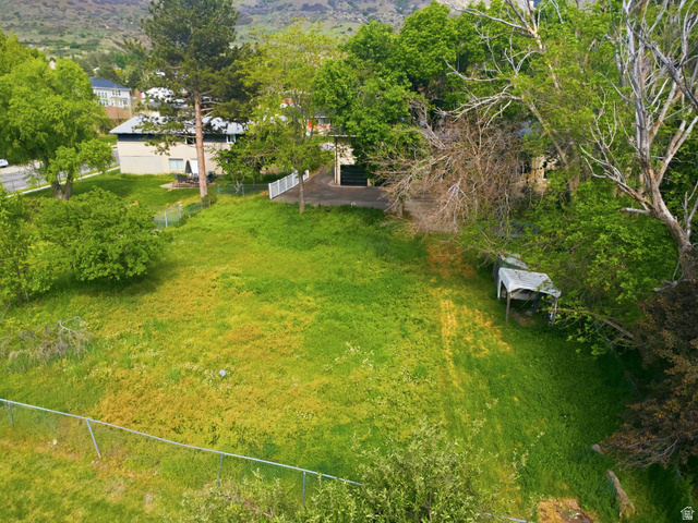 871 Bonita Way Centerville, UT 84014 - Photo 56 of 61 Expansive green space featuring mature trees and a chain-link fence