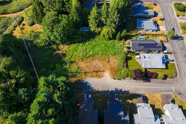 an aerial view of residential house with outdoor space and trees all around