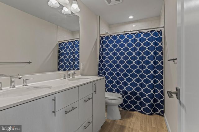 a bathroom with a sink a toilet a mirror and shower