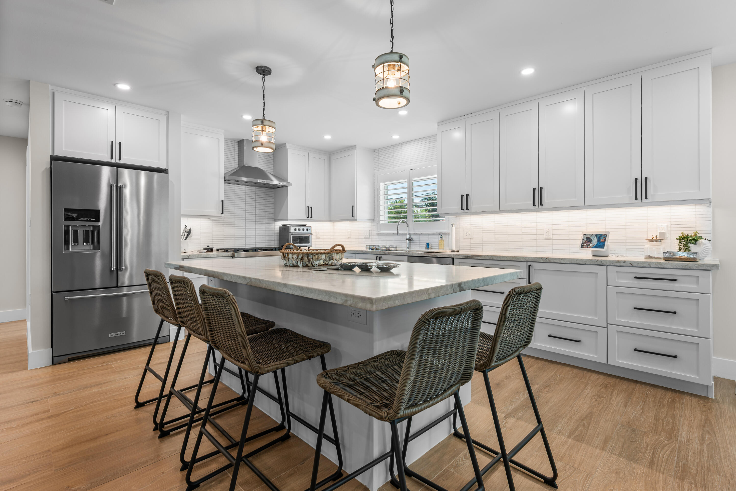 360 12th Street Key Colony Beach, FL 33051 - Photo 14 of 60 a kitchen with stainless steel appliances kitchen island granite countertop a dining table chairs refrigerator and cabinets