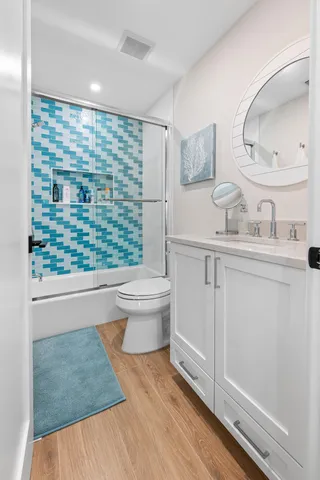 a kitchen with stainless steel appliances kitchen island granite countertop a stove a sink and a white cabinets