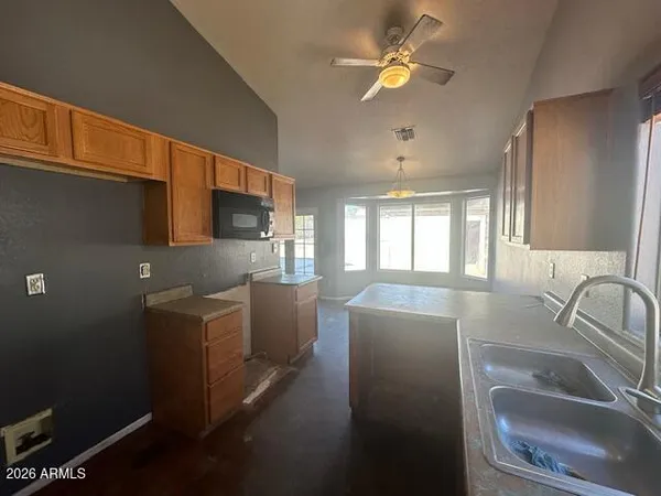 a kitchen with furniture a sink a window and stainless steel appliances