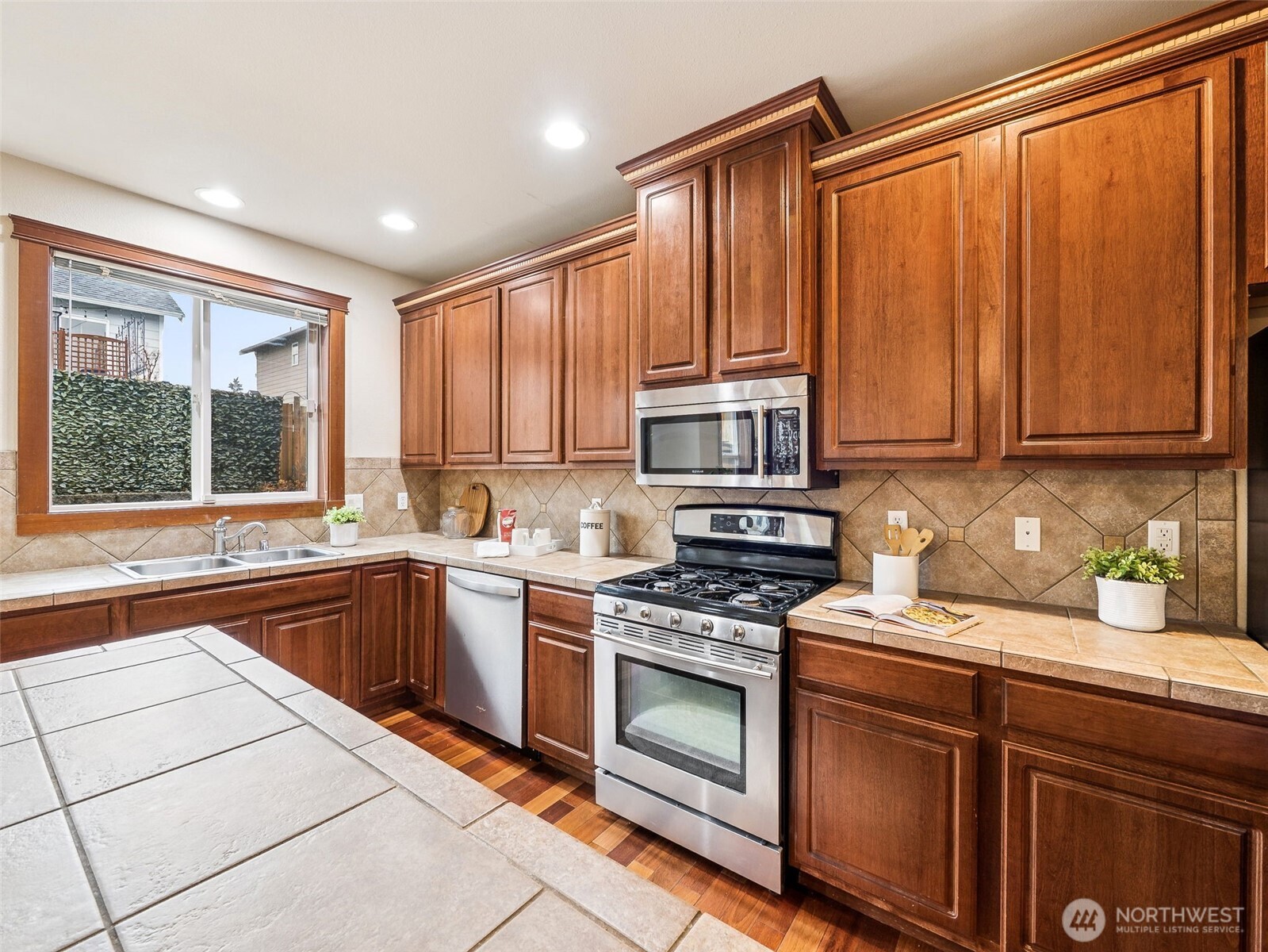 9432 202nd Street East Graham, WA 98338 - Photo 7 of 35 a kitchen with stainless steel appliances granite countertop a stove a sink and a microwave