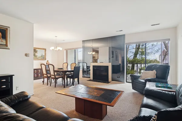 a living room with furniture wooden floor and a floor to ceiling window