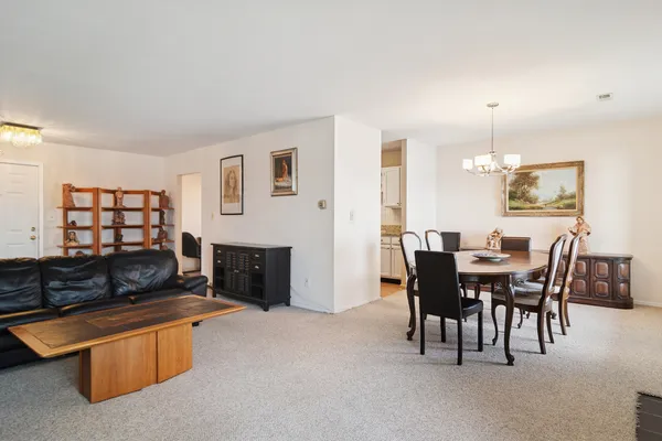 a view of a dining room with furniture and chandelier