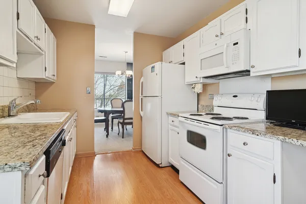 a kitchen with granite countertop a sink stove and refrigerator
