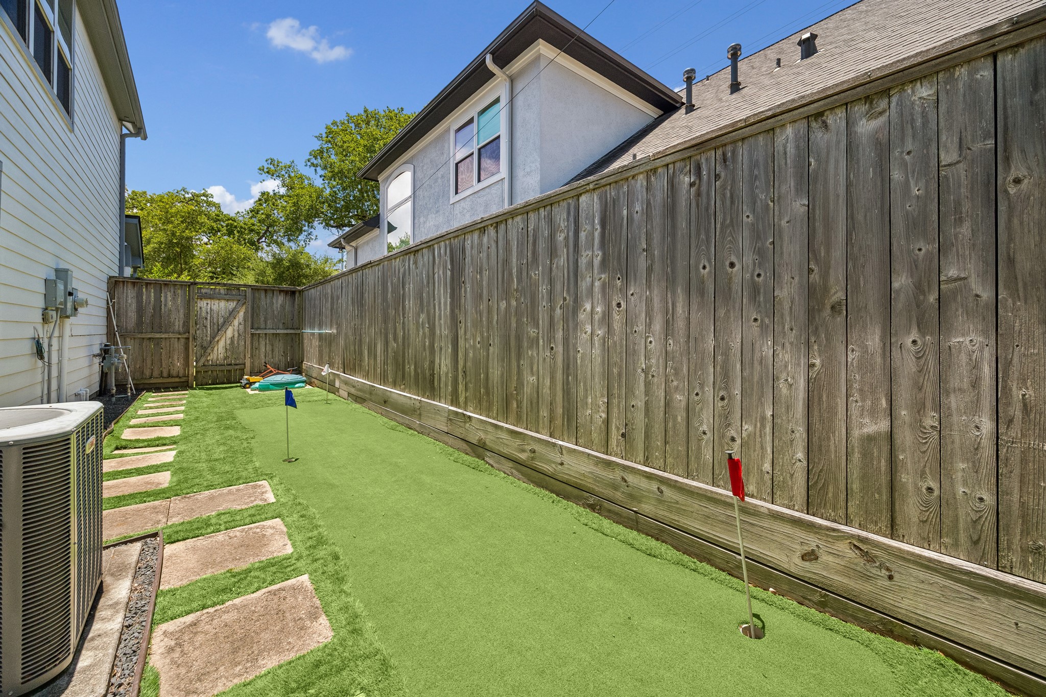 1360 Chippendale Road Houston, TX 77018 - Photo 30 of 34 Low-maintenance turfed side yard featuring a private putting green and additional recreational space. Rare outdoor amenity perfectly complements the pool, summer kitchen, and entertaining areas while creating a backyard experience that is both fun and functional.