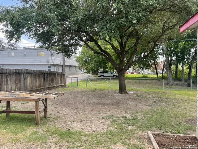 a backyard of a house with lots of green space and fountain