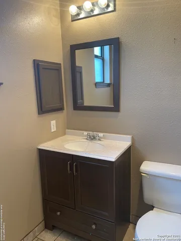 a bathroom with a toilet sink and mirror