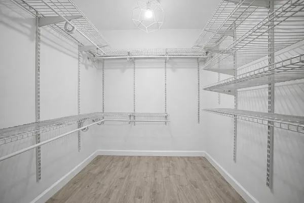 a view of an empty room with windows ceiling fan