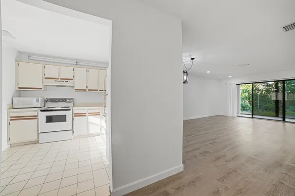 a view of empty room with wooden floor