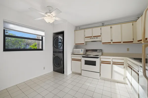 an empty room with wooden floor and ceiling fan