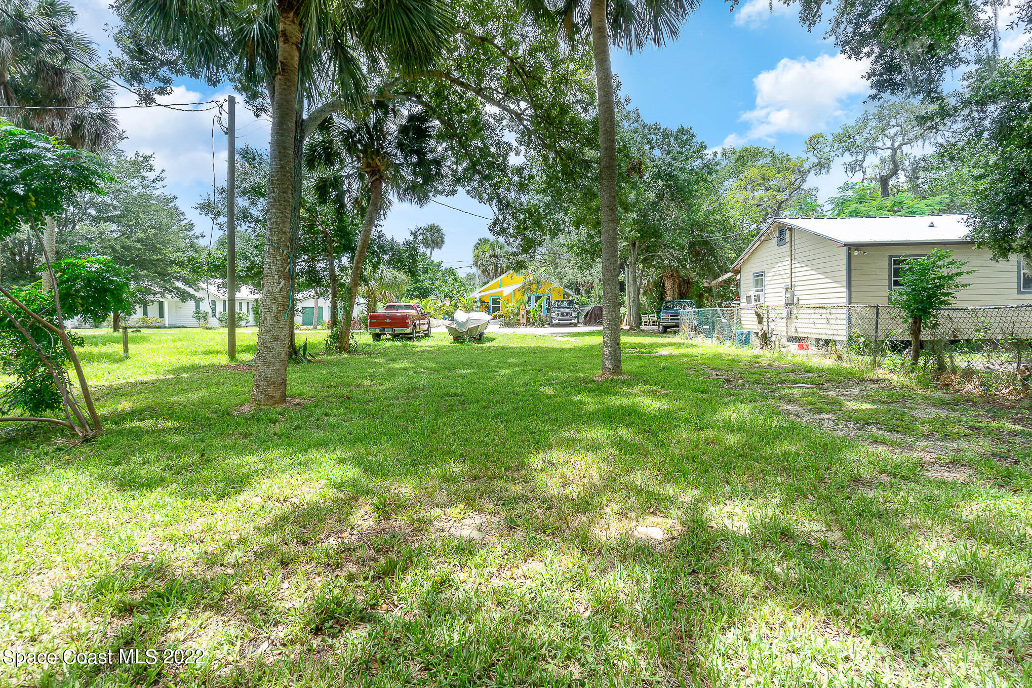 702 Shady Lane Melbourne, FL 32935 - Photo 3 of 4 a view of a house with a big yard and large trees