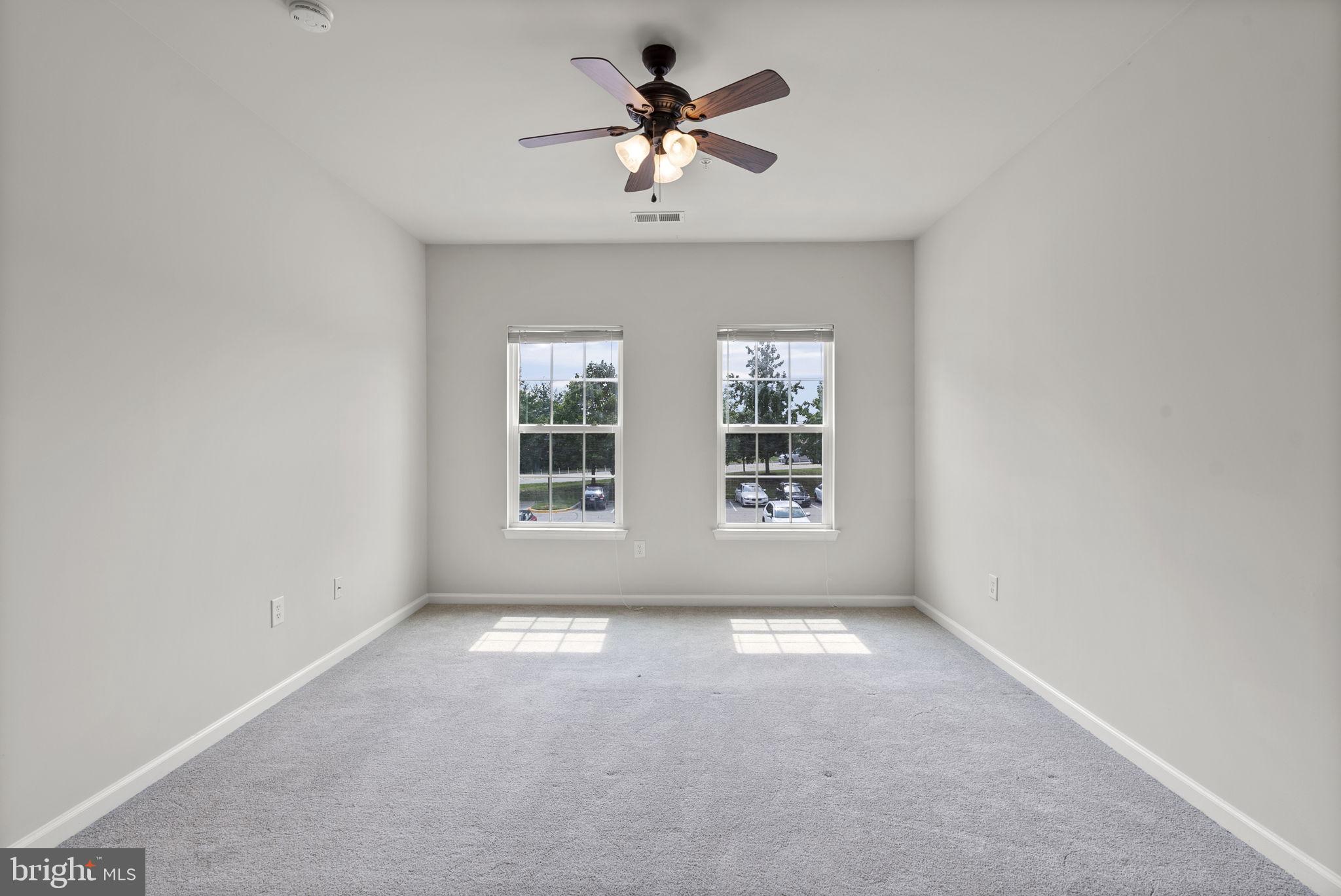 1622 Hardwick Court, Unit 201 Hanover, MD 21076 - Photo 35 of 42 an empty room with windows and chandelier fan