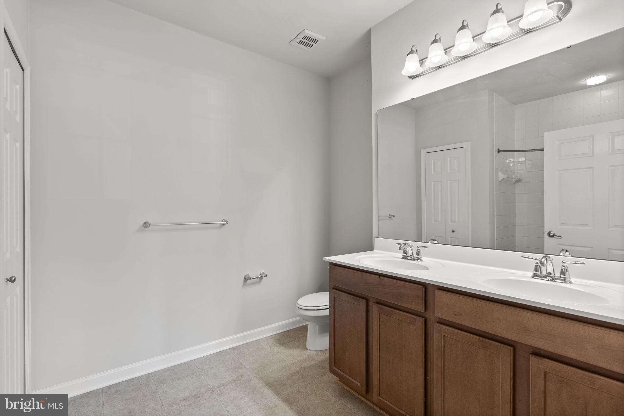 1622 Hardwick Court, Unit 201 Hanover, MD 21076 - Photo 37 of 42 a bathroom with a double vanity sink mirror and toilet