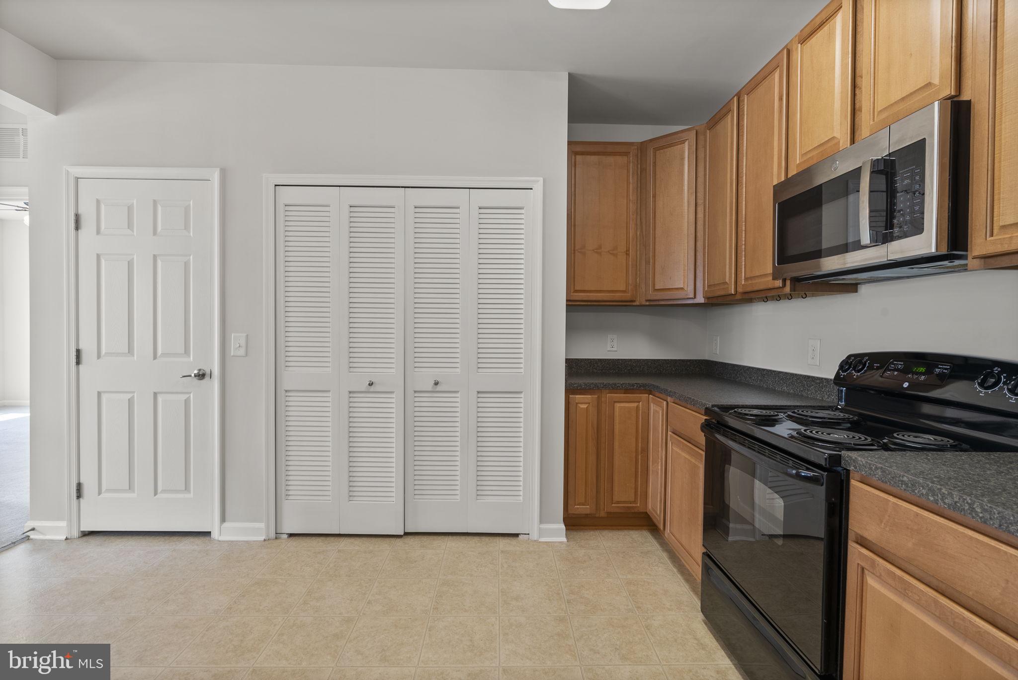1622 Hardwick Court, Unit 201 Hanover, MD 21076 - Photo 9 of 42 a kitchen with stainless steel appliances granite countertop white cabinets and a stove top oven