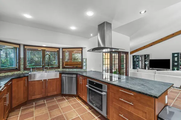 a kitchen with stainless steel appliances granite countertop a sink and a stove