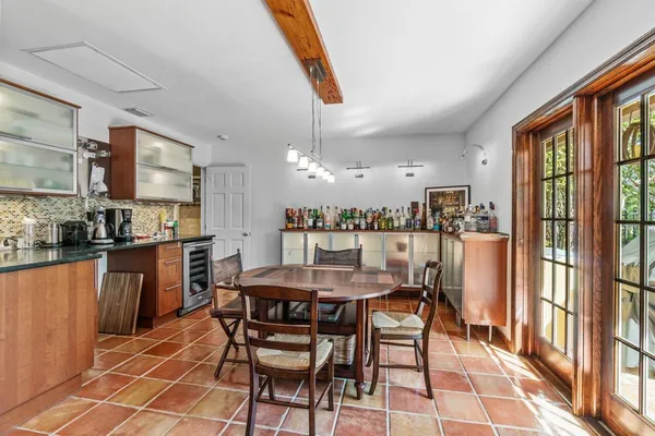 a kitchen with granite countertop a stove a sink a dining table and chairs