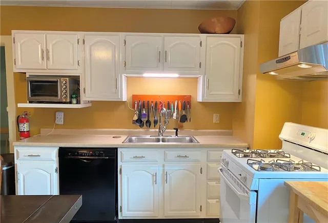 a kitchen with stainless steel appliances a stove a sink and a microwave