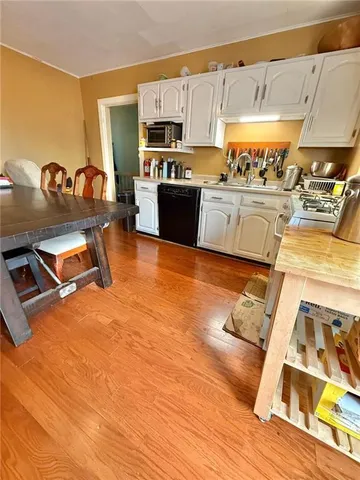 a kitchen with stainless steel appliances wooden floors and view living room