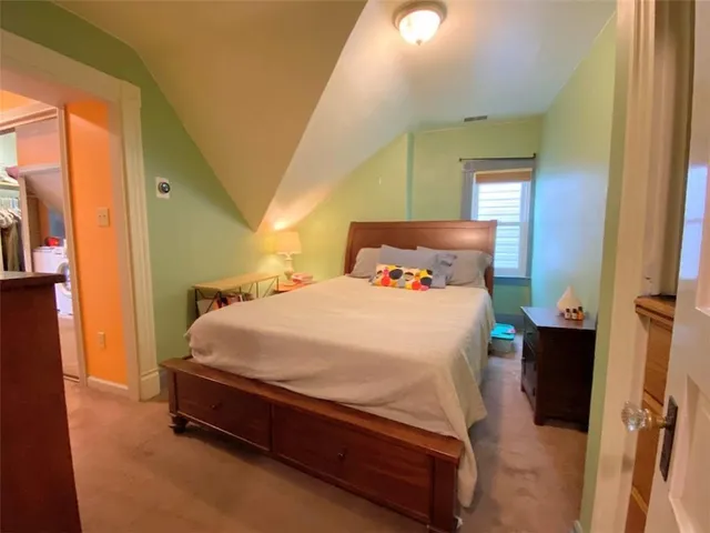 a bed sitting in a bedroom next to a window