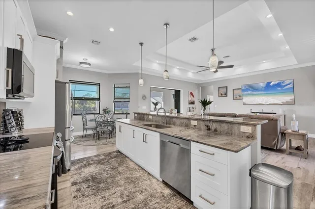 a kitchen with stainless steel appliances granite countertop a sink a stove and a refrigerator