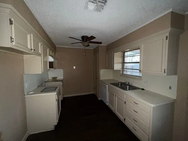 a kitchen with a sink stove and cabinets