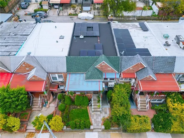 an aerial view of multiple houses with a yard