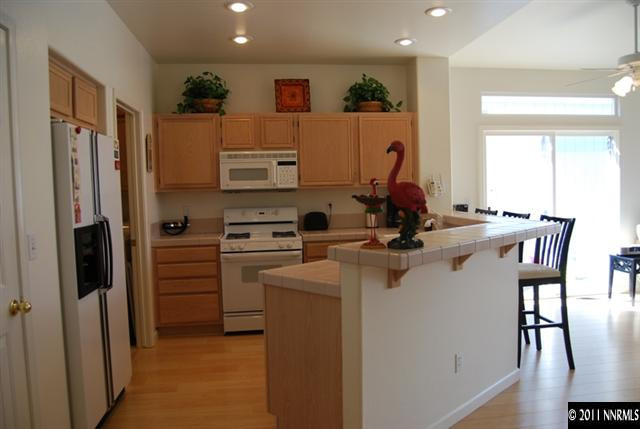 659 Caughlin Glen Reno, NV 89519 - Photo 4 of 12 a kitchen with refrigerator and chairs