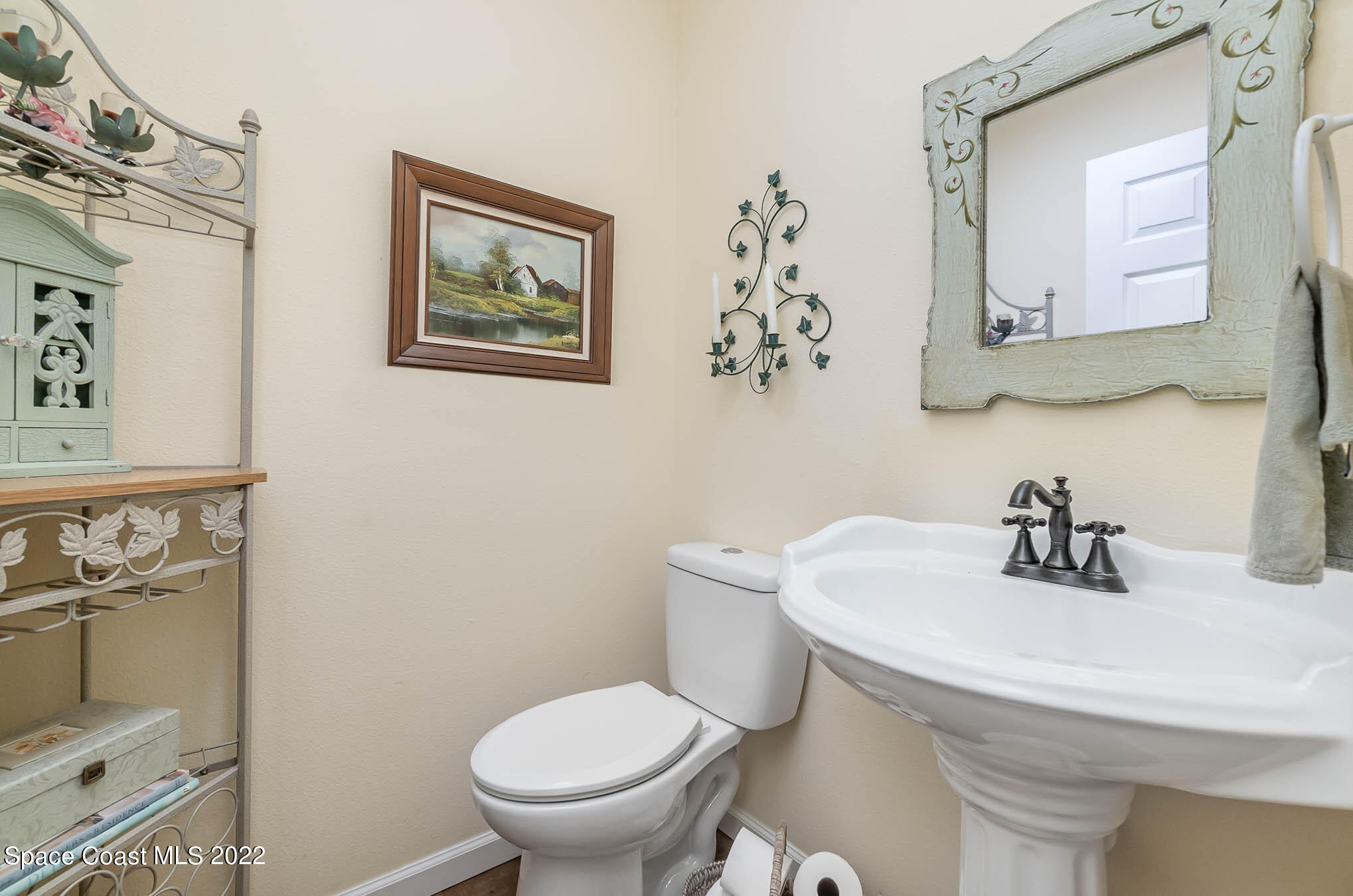 3895 Corey Road Malabar, FL 32950 - Photo 15 of 21 a bathroom with a toilet sink and mirror