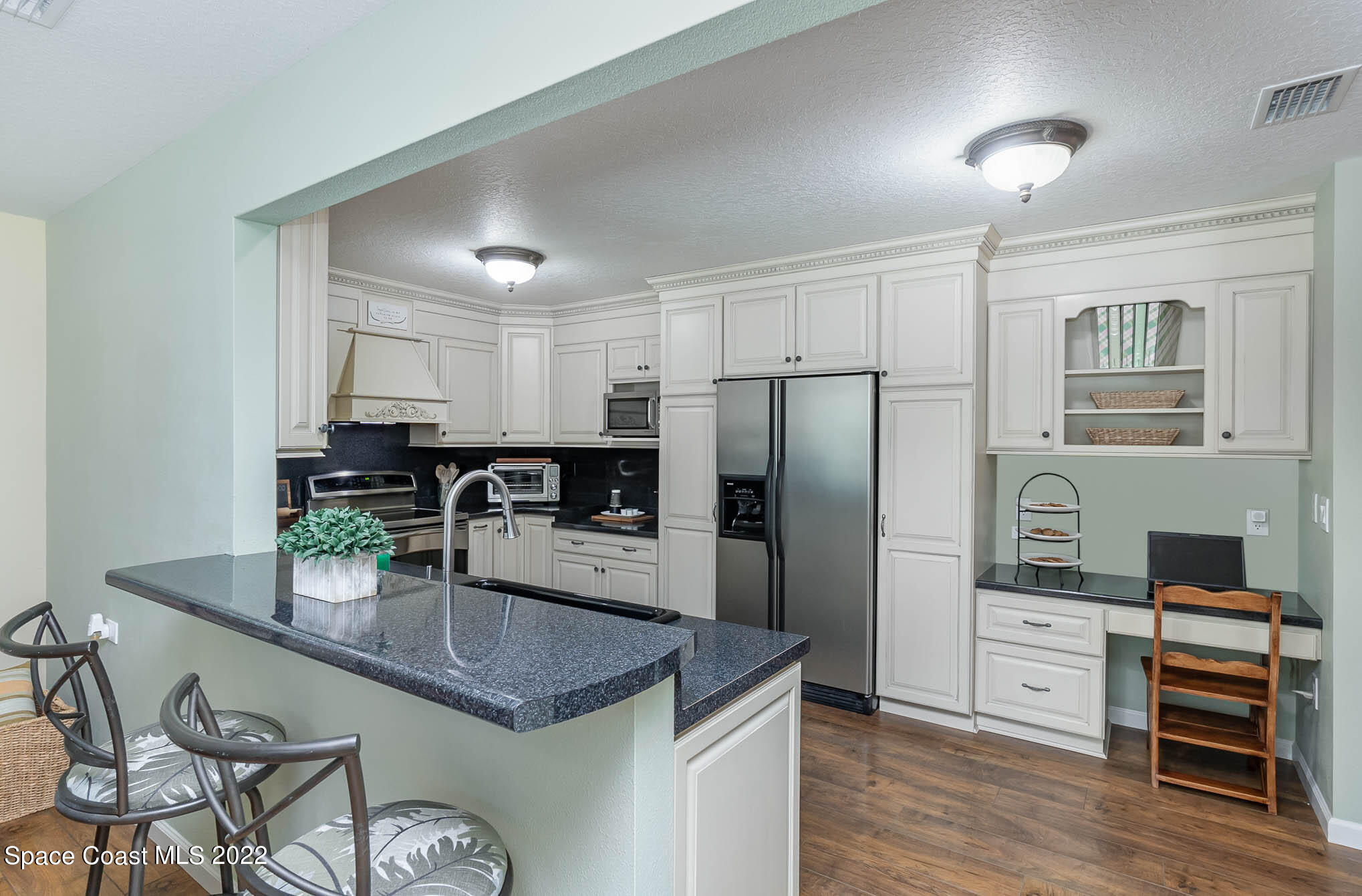 3895 Corey Road Malabar, FL 32950 - Photo 5 of 21 a kitchen with refrigerator cabinets and wooden floor