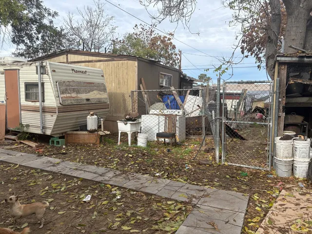 a view of a patio with table and chairs under an umbrella with large tree